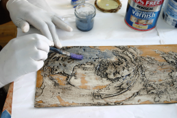 Painting the carborundum/varnish mixture onto the plate surface